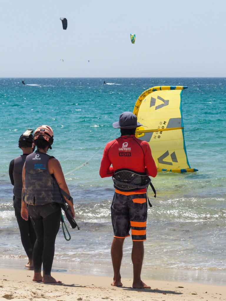 Cursos de Kitesurf Niños 5 Alumnos escuchando las explicaciones del instructor en una clase semi privada en Tarifa"