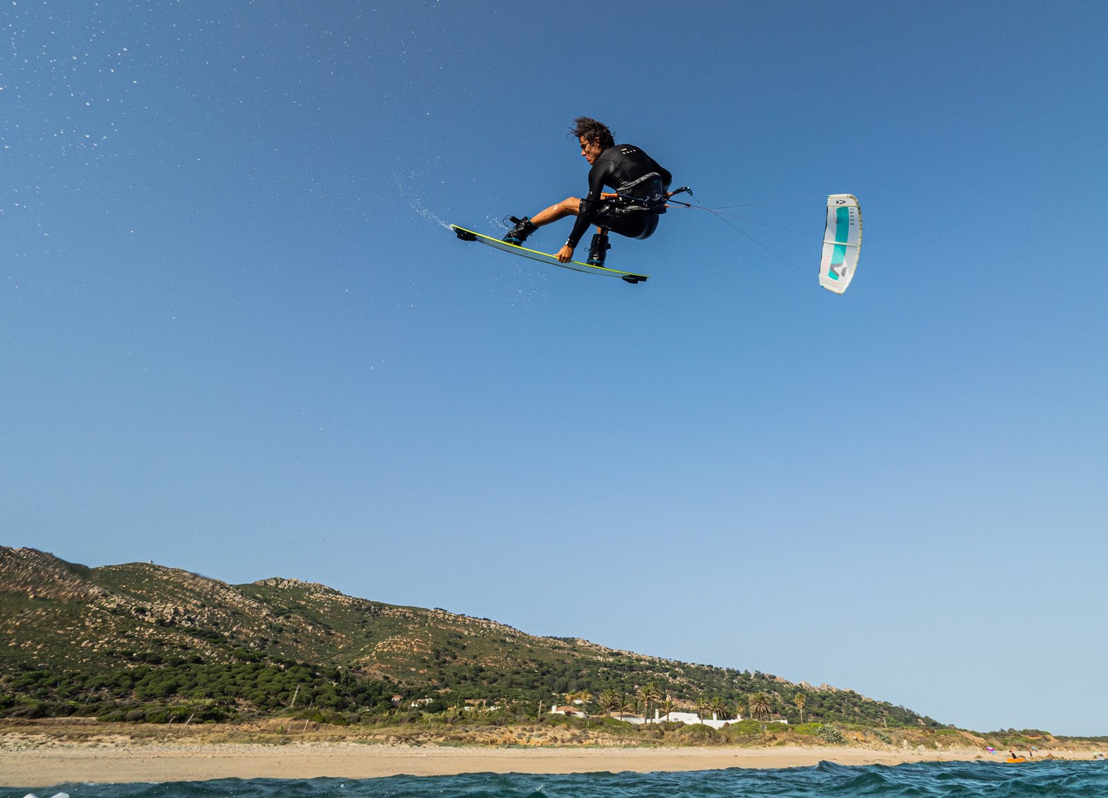 Alumno realizando una maniobra avanzada de freestyle durante un curso de kitesurf en Tarifa